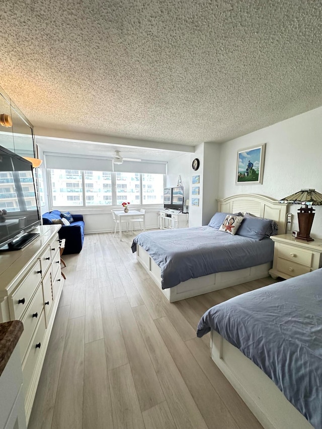 bedroom with a textured ceiling and light wood-type flooring