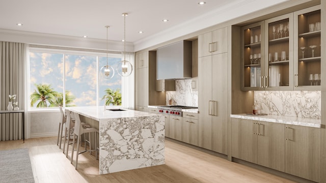 kitchen featuring light wood-type flooring, decorative light fixtures, light stone counters, and wall chimney range hood