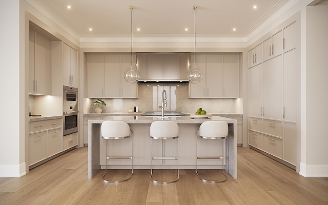 kitchen featuring a center island with sink, pendant lighting, wall chimney range hood, and light wood-type flooring