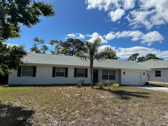 single story home featuring a front lawn and a garage