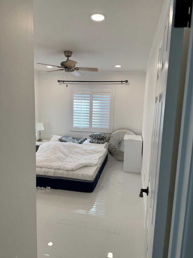 tiled bedroom with crown molding and ceiling fan