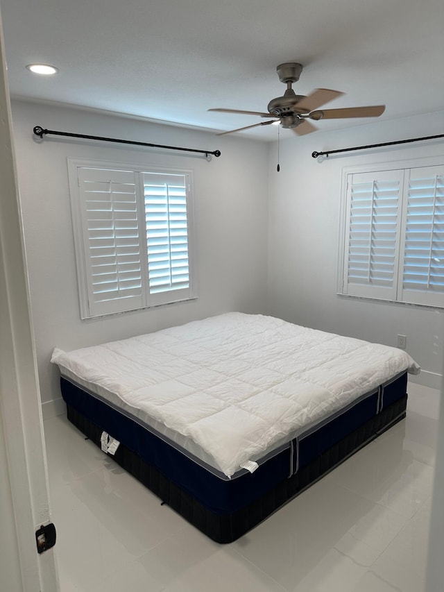 bedroom with ceiling fan and light tile floors