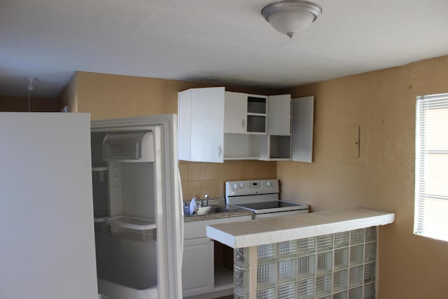 kitchen featuring white cabinetry, backsplash, and electric range