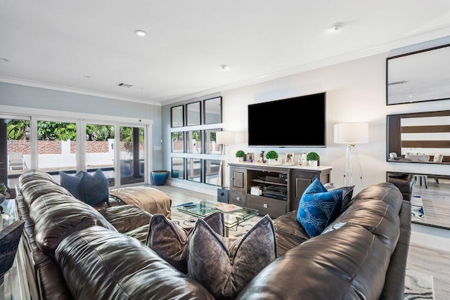 living room with light hardwood / wood-style floors, french doors, and crown molding