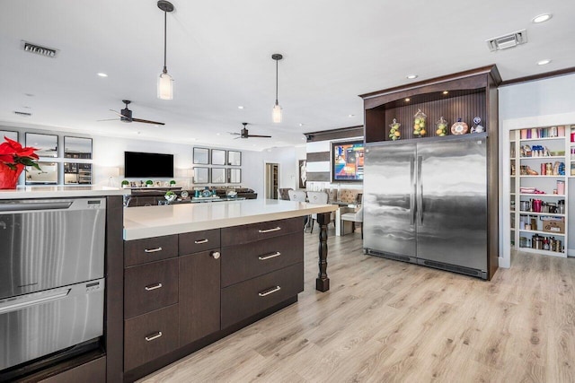 kitchen with stainless steel fridge, ceiling fan, hanging light fixtures, light hardwood / wood-style floors, and dark brown cabinetry