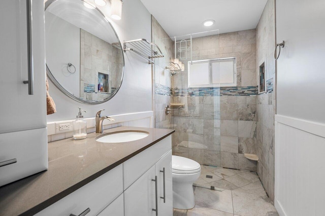 bathroom featuring toilet, tile flooring, a tile shower, and vanity