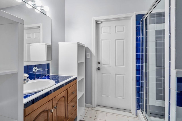 bathroom with vanity with extensive cabinet space, tile flooring, and a shower with shower door