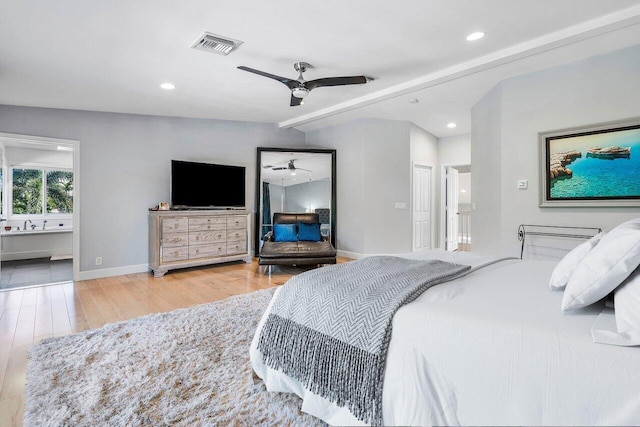 tiled bedroom with ensuite bathroom, ceiling fan, and beamed ceiling