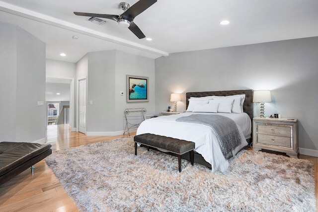 bedroom featuring a closet, beam ceiling, ceiling fan, and light wood-type flooring