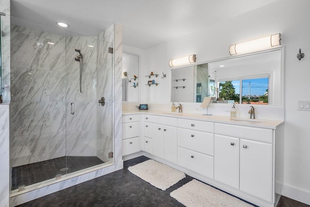 bathroom featuring double sink, a shower with shower door, and large vanity