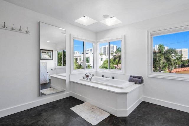 bathroom featuring a skylight, tile floors, and a bath