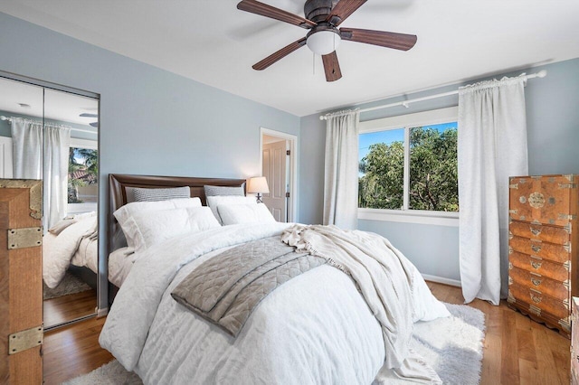 bedroom with light hardwood / wood-style floors, a closet, and ceiling fan