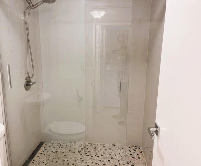 bathroom featuring walk in shower and toilet