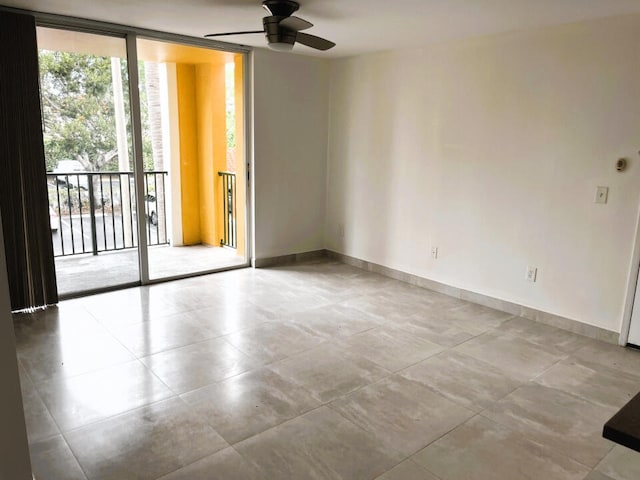 spare room with light tile floors, expansive windows, and ceiling fan