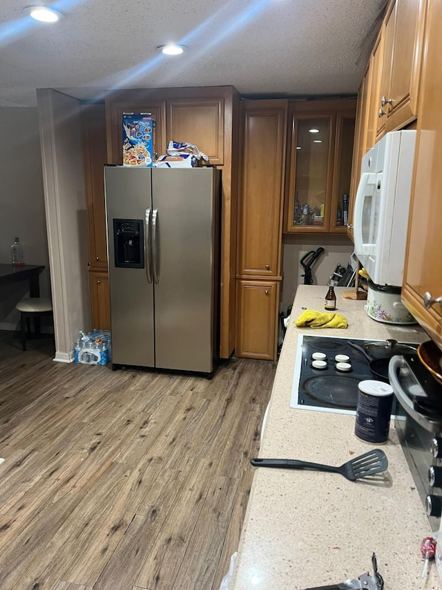 kitchen featuring a textured ceiling, stainless steel fridge with ice dispenser, and light wood-type flooring