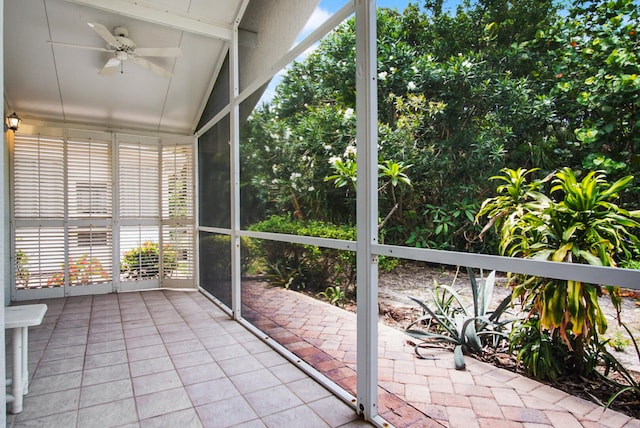 unfurnished sunroom featuring ceiling fan and vaulted ceiling