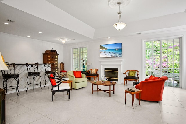 living room with a tray ceiling and light tile floors