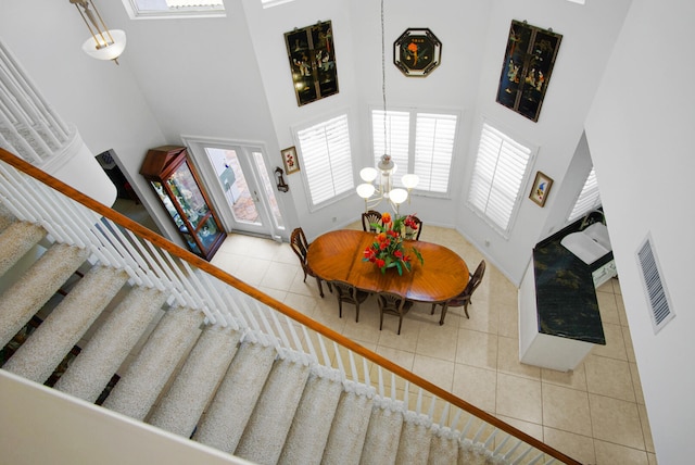 tiled living room with a high ceiling and an inviting chandelier