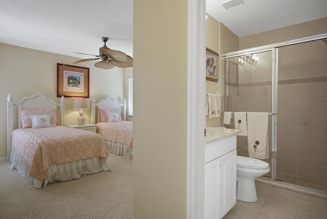 bedroom with light carpet, ensuite bath, and ceiling fan