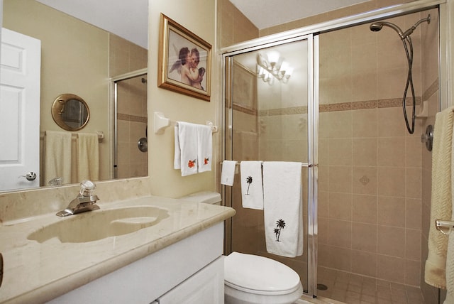 bathroom with a shower with shower door, vanity, and toilet