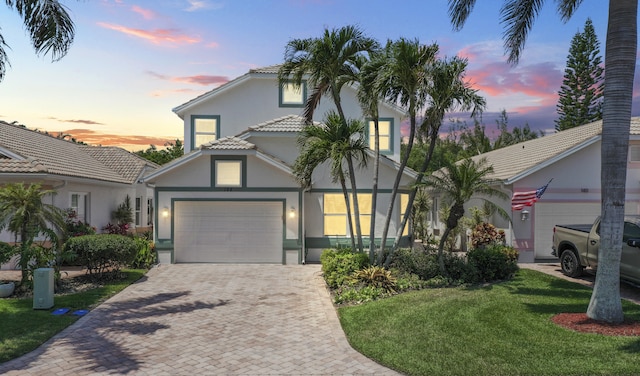 view of front of property with a garage and a lawn