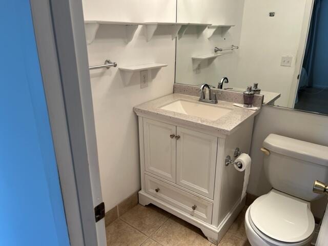 bathroom featuring vanity, tile floors, and toilet