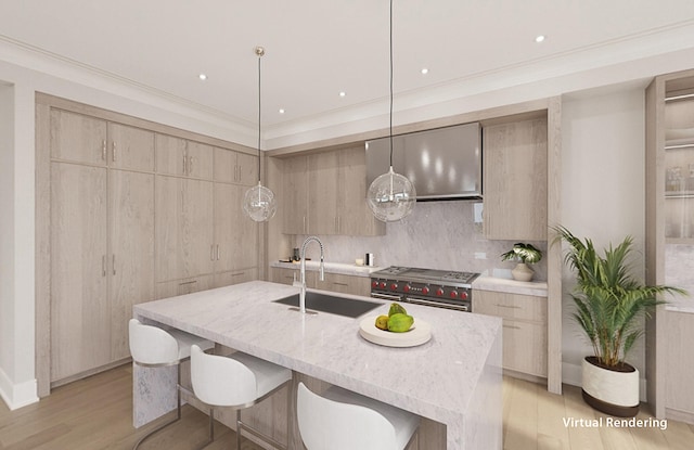 kitchen featuring high end stainless steel range, pendant lighting, a center island with sink, sink, and light wood-type flooring