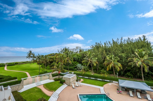 view of pool with a water view, a lawn, and a patio