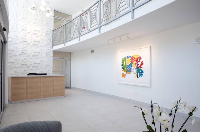 tiled living room with a high ceiling and track lighting