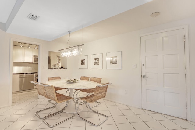 tiled dining room with an inviting chandelier