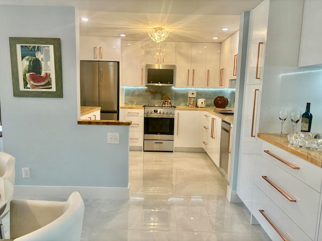 kitchen with white cabinetry, hanging light fixtures, appliances with stainless steel finishes, and tasteful backsplash