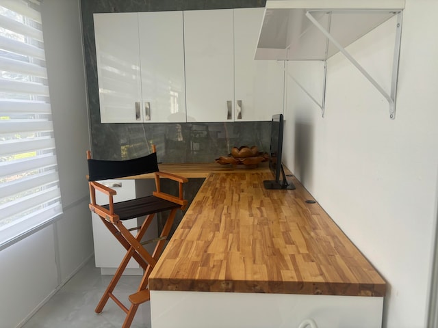 kitchen featuring white cabinetry and butcher block counters