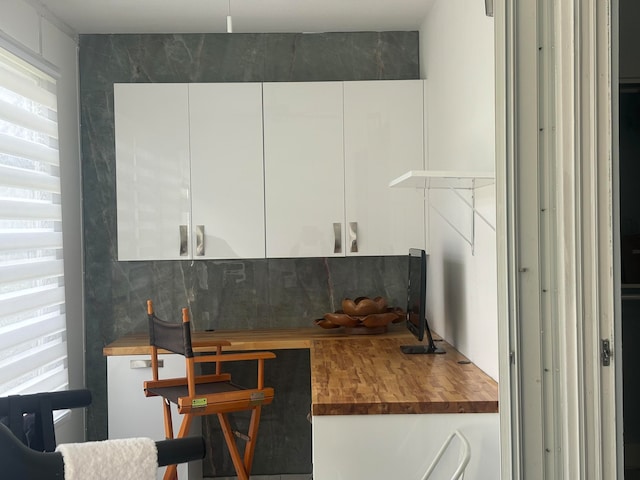 kitchen with white cabinets and butcher block countertops