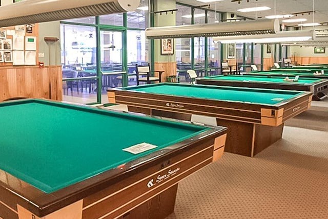 recreation room with carpet and wood walls