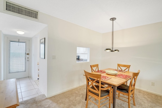 dining space featuring an inviting chandelier and light colored carpet