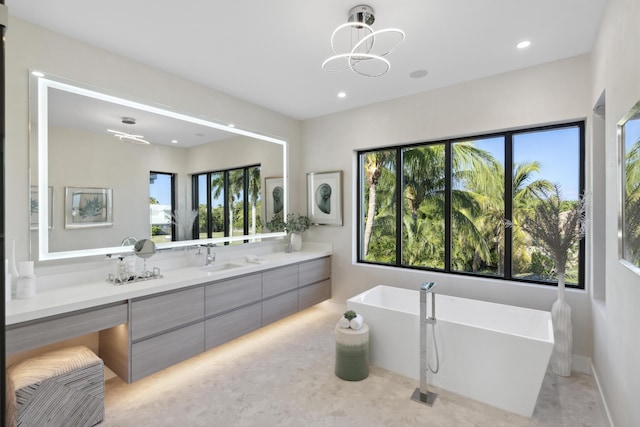 full bathroom featuring vanity, a soaking tub, recessed lighting, and baseboards