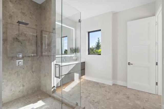 bathroom featuring vanity, baseboards, and a stall shower