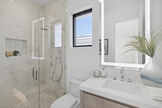 full bath with a marble finish shower, toilet, and vanity