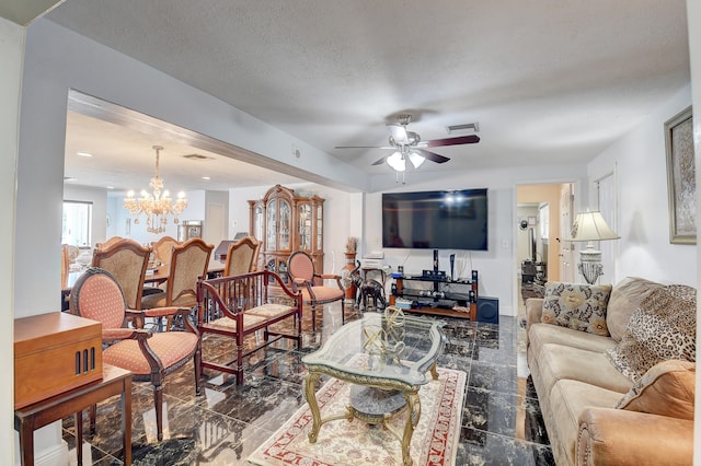 tiled living room with a textured ceiling and ceiling fan with notable chandelier