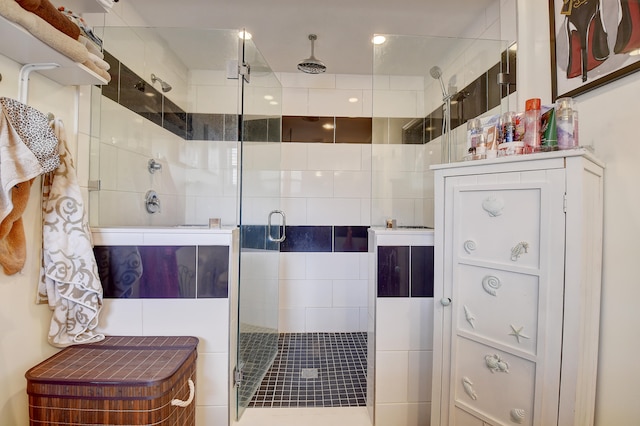 bathroom with a shower with door and tile walls