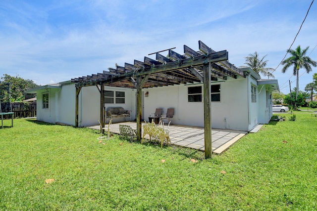 rear view of house featuring a patio area, a pergola, and a lawn