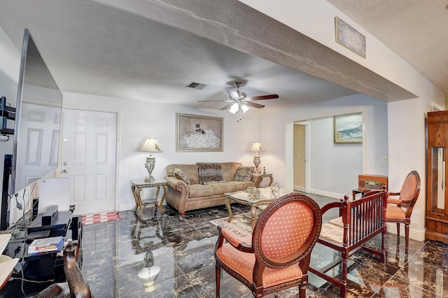 tiled living room with ceiling fan and a textured ceiling