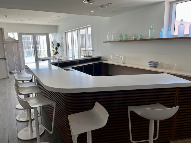 bar with sink and light wood-type flooring