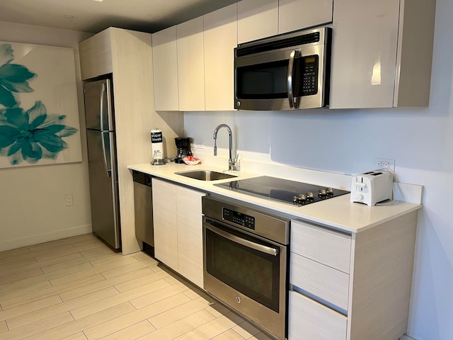 kitchen with white cabinetry, sink, and stainless steel appliances