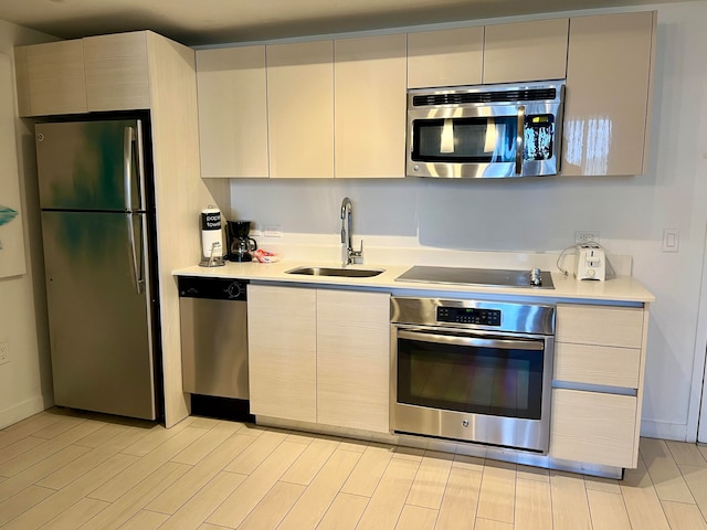 kitchen with light hardwood / wood-style flooring, sink, and stainless steel appliances