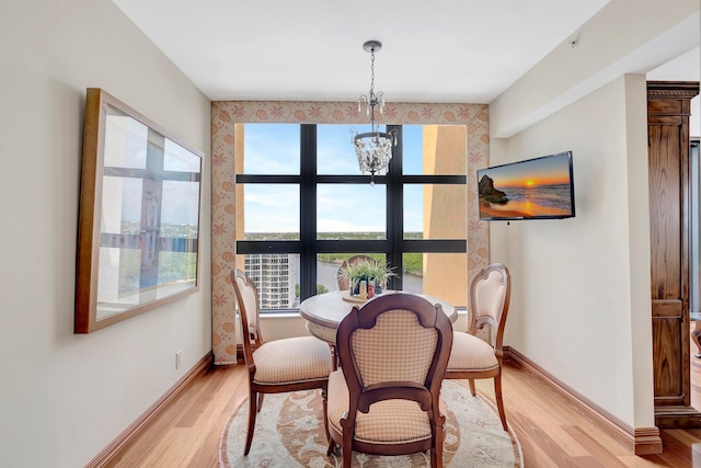 dining area with an inviting chandelier and light hardwood / wood-style flooring