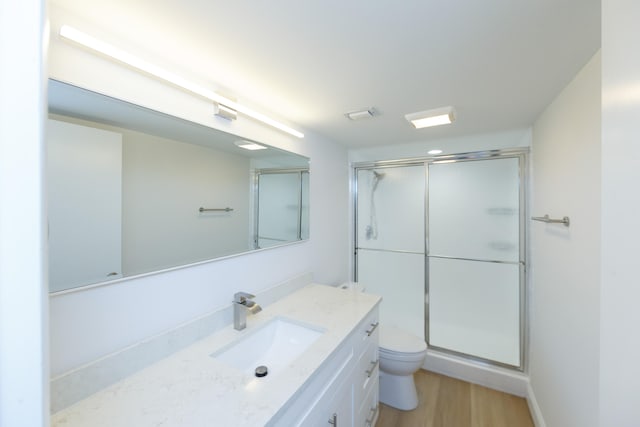 bathroom with vanity, hardwood / wood-style floors, toilet, and walk in shower