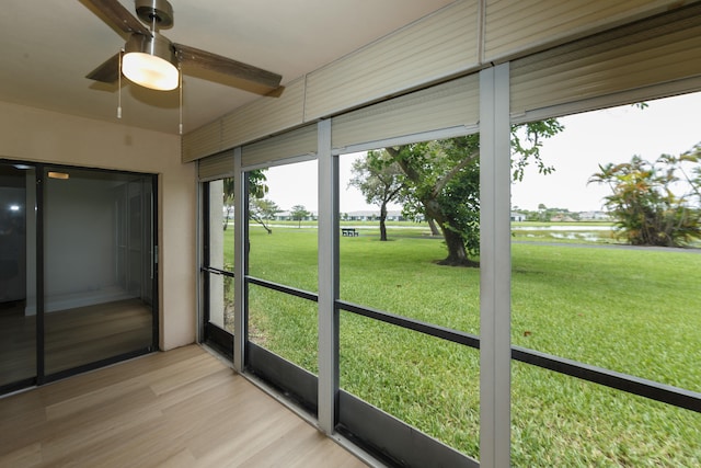 unfurnished sunroom with ceiling fan