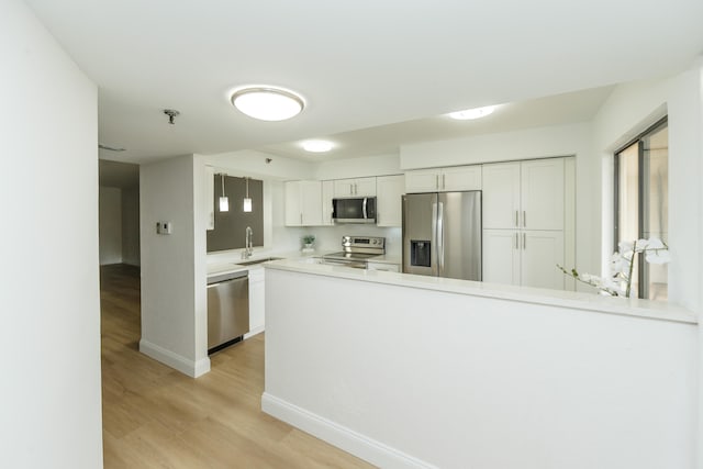 kitchen featuring light hardwood / wood-style floors, stainless steel appliances, white cabinetry, and sink