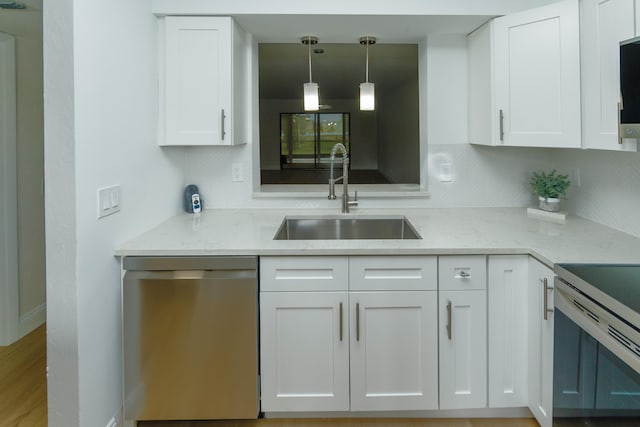 kitchen featuring hanging light fixtures, white cabinets, sink, and dishwasher